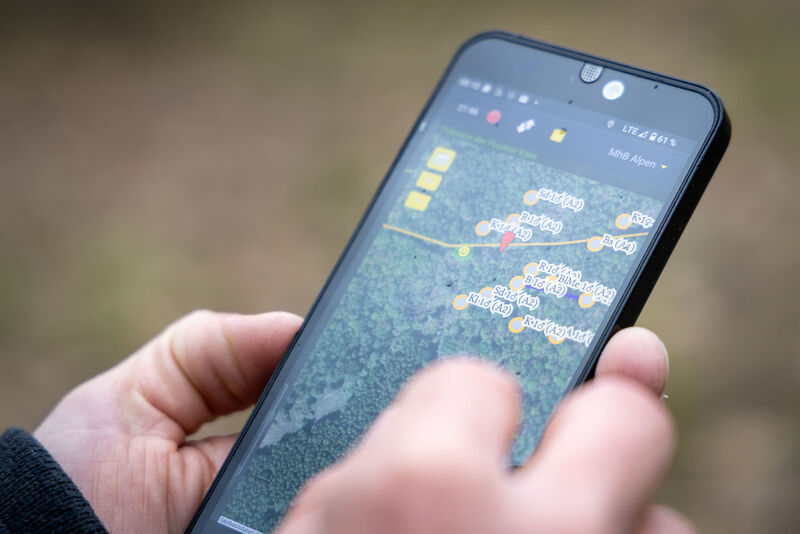 Handy mit einer Karten-Ap in der Hand 