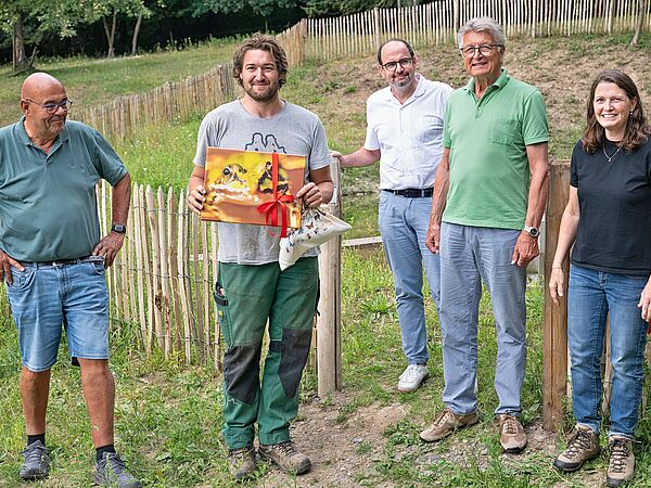 5 Personen stehen auf einem Grundstück und blicken in die Kamera