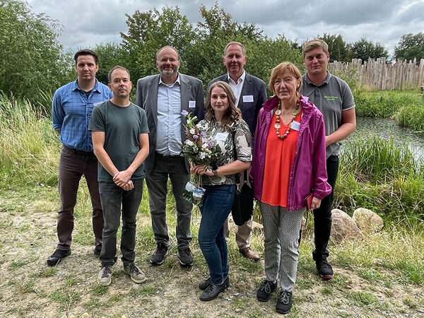 Gruppenfoto mit den Rednerinnen und Rednern am 19.07.2023 am renaturierten Dorfteich in Gingst. Gruppenfoto mit sieben Personen vor einem naturnahen Teich.