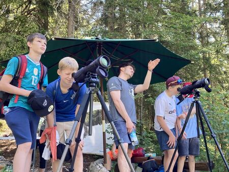 Kinder stehen mit einer Filmkamera und schauen in den Horizont